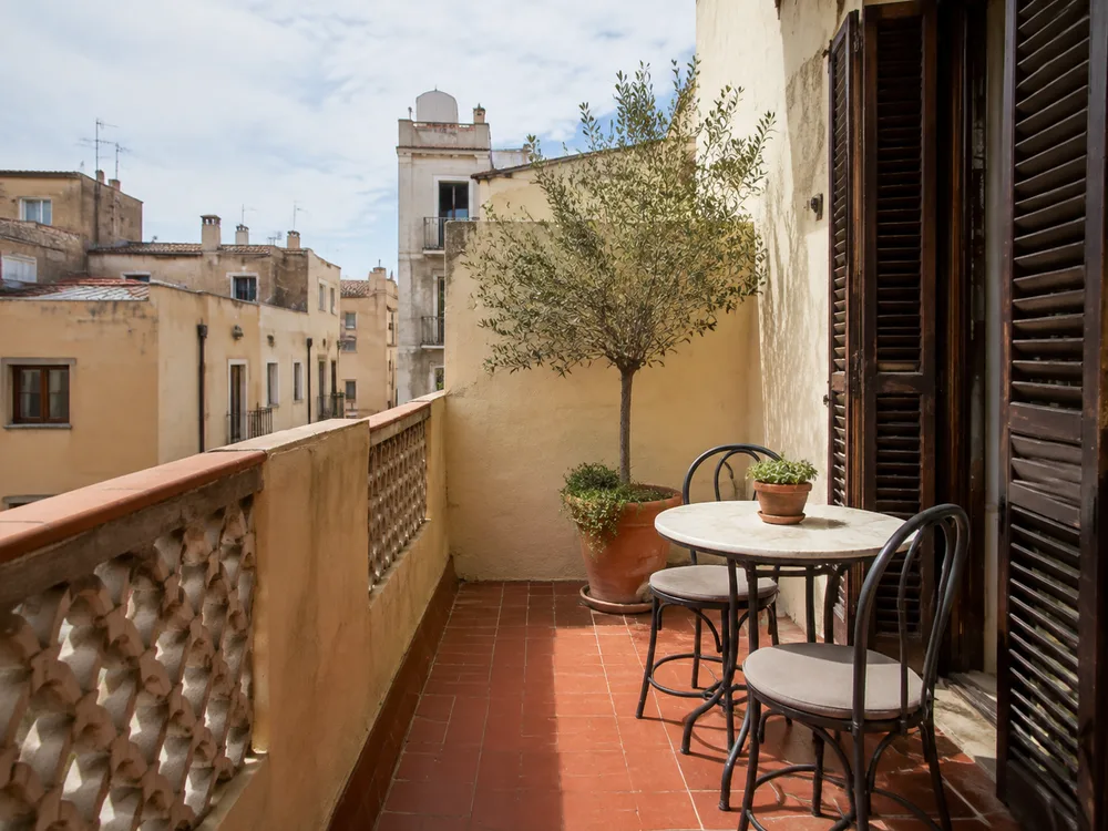 Terraza con suelo de terracota, plantas y una mesa al aire libre